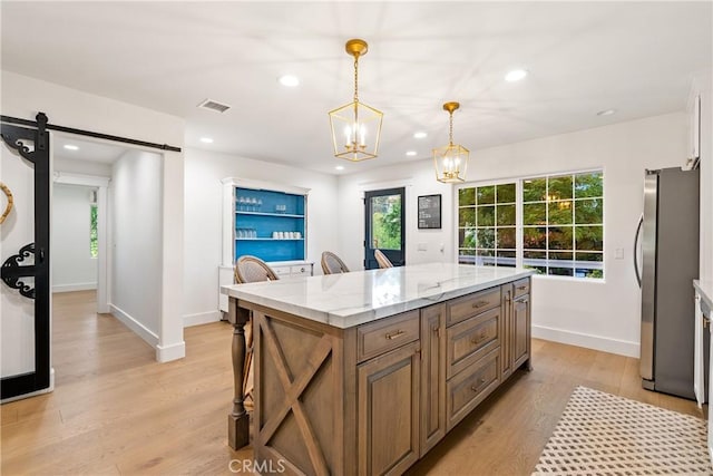 kitchen featuring a barn door, freestanding refrigerator, recessed lighting, baseboards, and visible vents