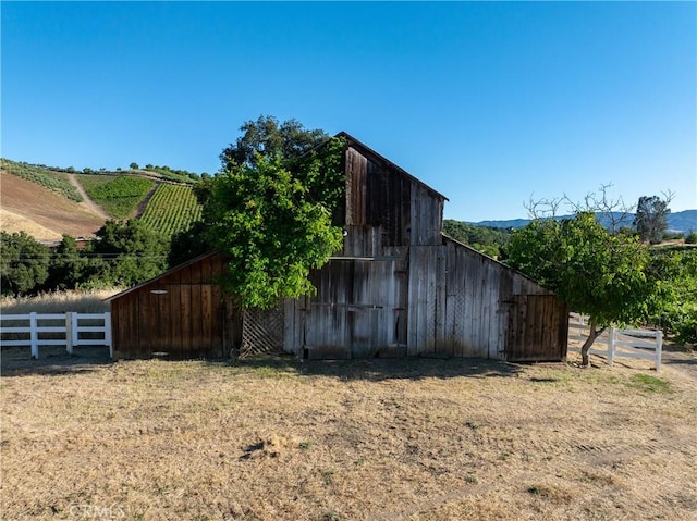 view of barn featuring fence