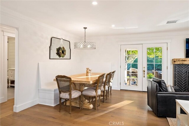 dining space with visible vents, wood finished floors, baseboards, recessed lighting, and french doors