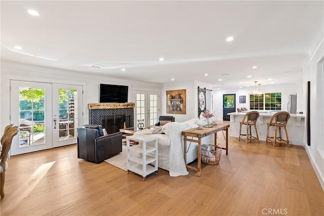 living area featuring recessed lighting, french doors, and light wood-type flooring