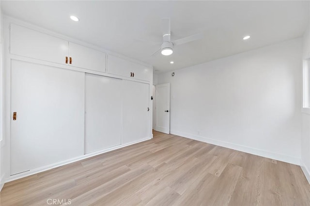 unfurnished bedroom featuring ceiling fan, a closet, and light hardwood / wood-style flooring