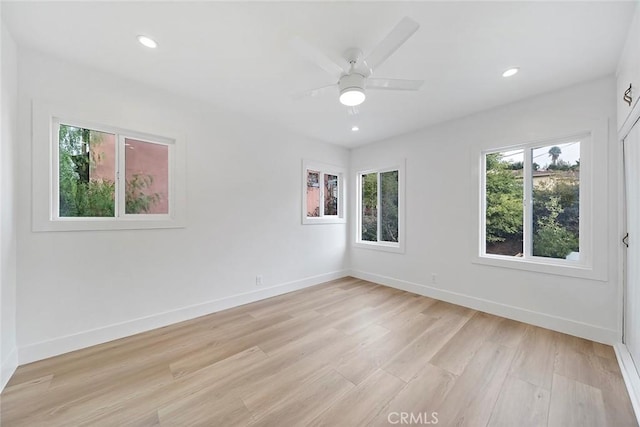 empty room with ceiling fan, light wood-type flooring, and a wealth of natural light