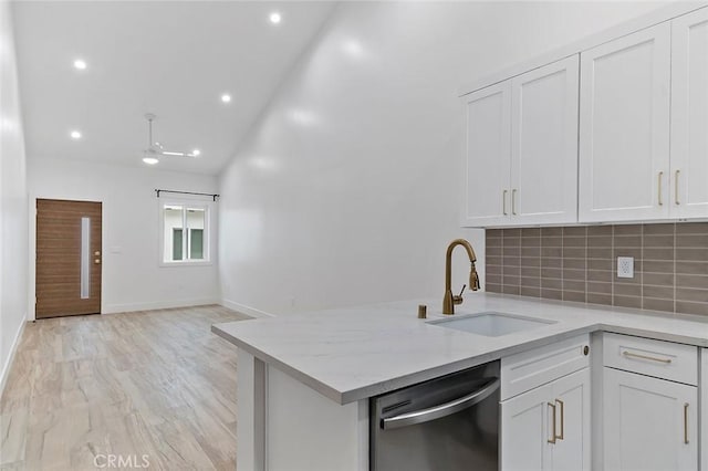 kitchen featuring stainless steel dishwasher, white cabinets, light wood-type flooring, and sink