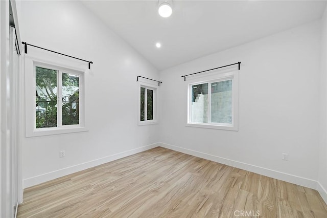 unfurnished room with lofted ceiling and light hardwood / wood-style flooring