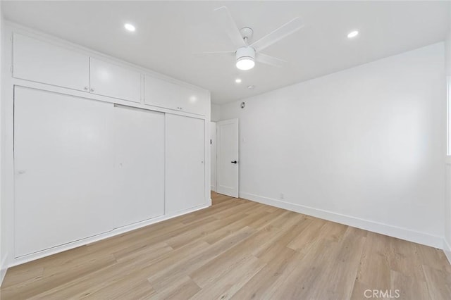 unfurnished bedroom with a closet, light hardwood / wood-style flooring, and ceiling fan