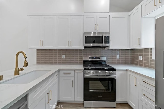 kitchen featuring white cabinetry, sink, and appliances with stainless steel finishes