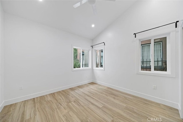 empty room featuring high vaulted ceiling and light hardwood / wood-style floors