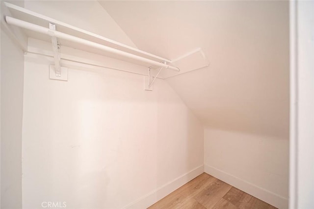 spacious closet with wood-type flooring and vaulted ceiling