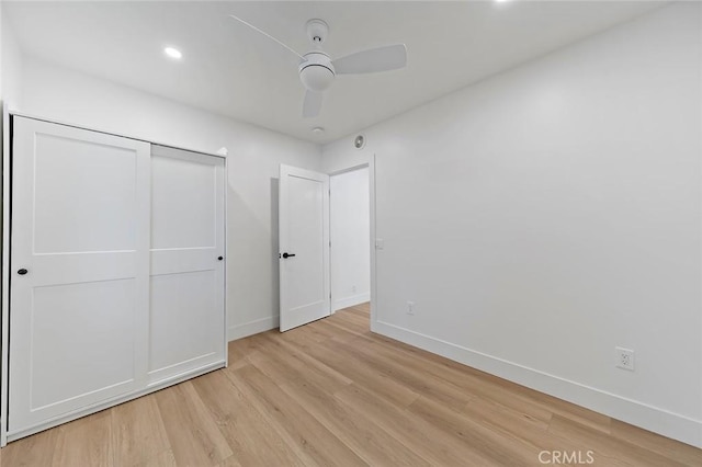 unfurnished bedroom with ceiling fan, a closet, and light hardwood / wood-style floors