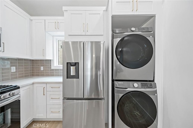 clothes washing area with stacked washer and dryer and light hardwood / wood-style floors