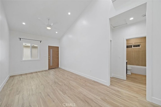 spare room with high vaulted ceiling, light hardwood / wood-style flooring, and ceiling fan