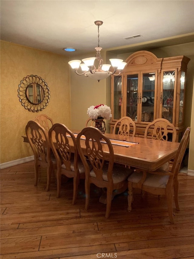 dining room with a notable chandelier and dark hardwood / wood-style floors