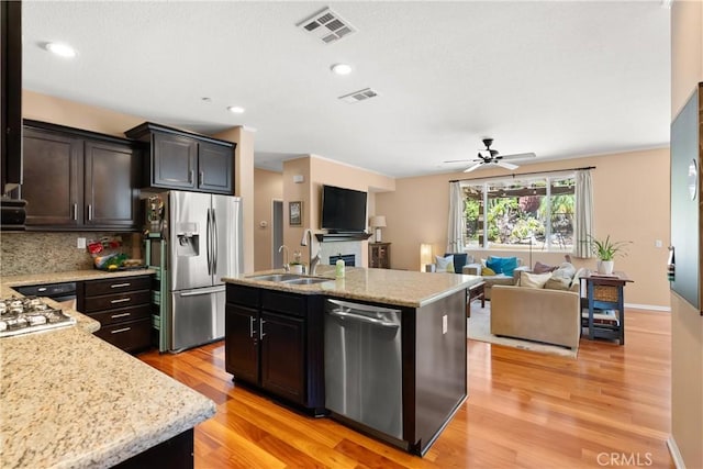 kitchen with a center island with sink, sink, light hardwood / wood-style flooring, ceiling fan, and stainless steel appliances