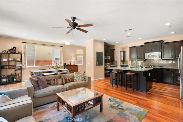 living room featuring ceiling fan and light hardwood / wood-style floors