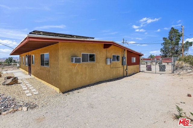 view of side of property featuring an AC wall unit