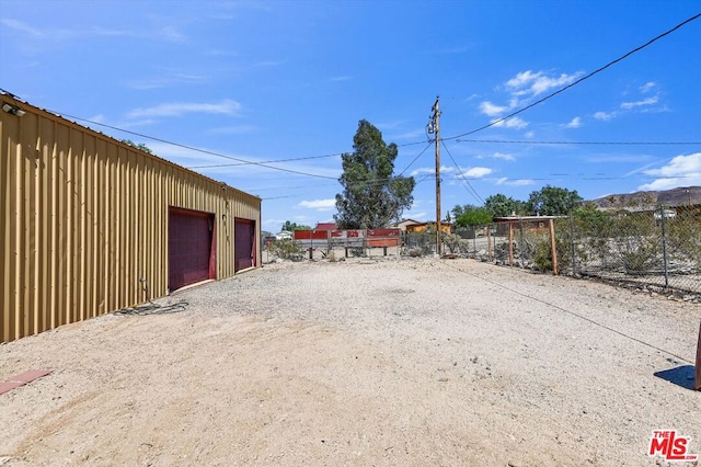 view of yard with a garage and an outbuilding