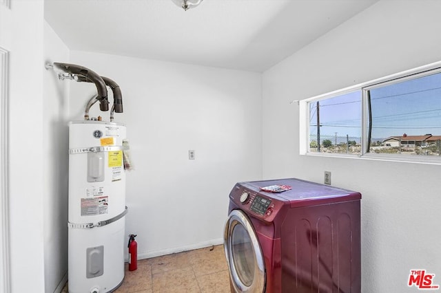 clothes washing area featuring strapped water heater and washer / dryer