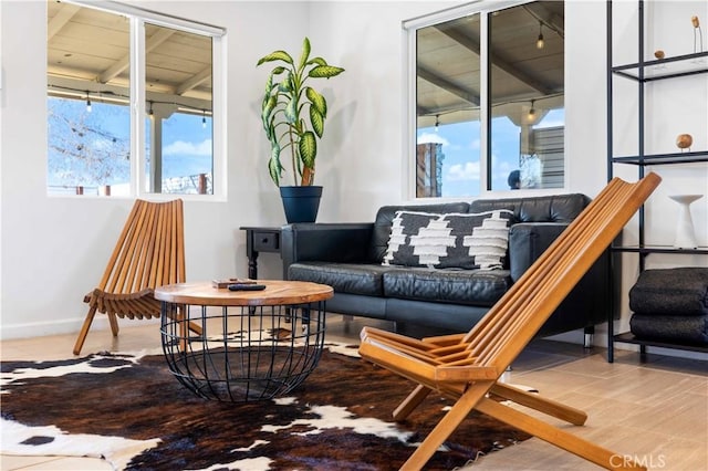 sitting room with beamed ceiling and baseboards