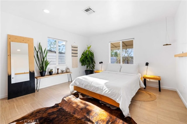 bedroom with light wood-style floors, recessed lighting, visible vents, and baseboards