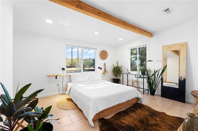 bedroom with visible vents, light wood finished floors, beam ceiling, and recessed lighting