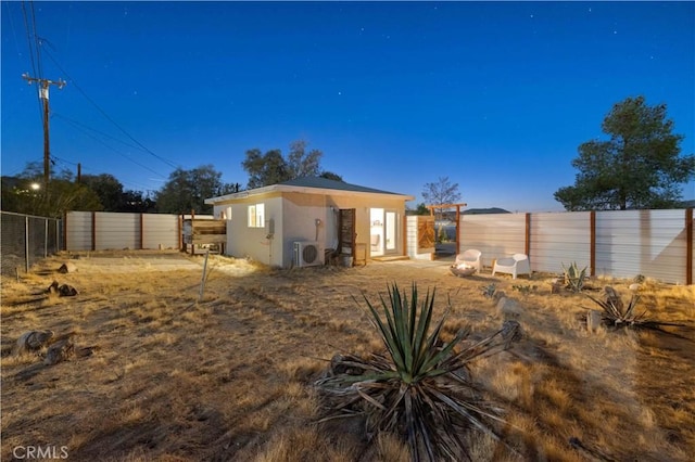back of property featuring ac unit, a fenced backyard, and stucco siding