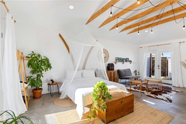 bedroom with lofted ceiling with beams, concrete floors, and french doors