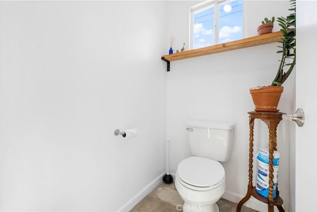 half bath with toilet and baseboards