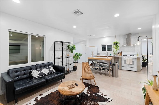 living area featuring visible vents and recessed lighting