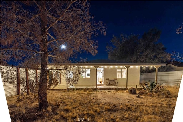 view of front of house featuring fence and stucco siding