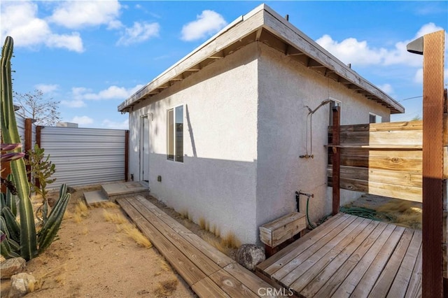 view of property exterior with fence and stucco siding