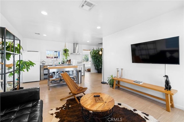 living area featuring recessed lighting, visible vents, and baseboards