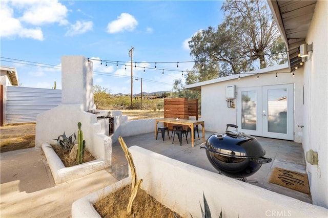 view of patio with outdoor dining area, grilling area, and french doors