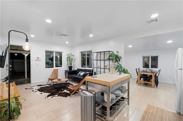 living room with baseboards, visible vents, and recessed lighting