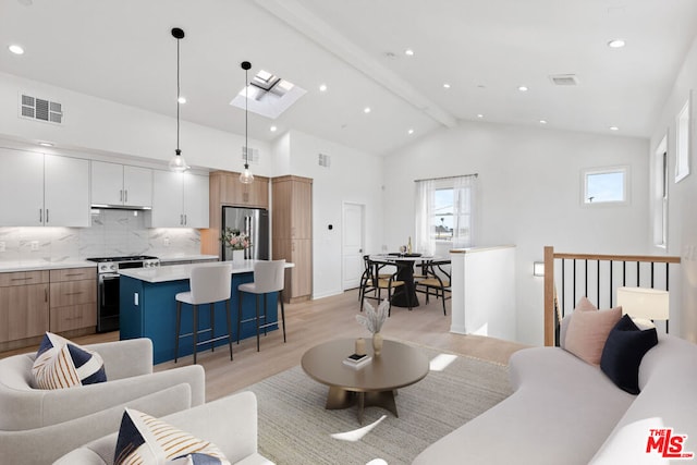 living room featuring beam ceiling, high vaulted ceiling, a skylight, and light hardwood / wood-style flooring