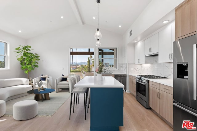 kitchen with a center island, hanging light fixtures, stainless steel appliances, white cabinets, and light wood-type flooring