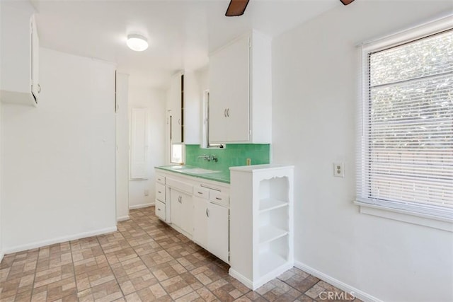 bathroom featuring tasteful backsplash, ceiling fan, and sink