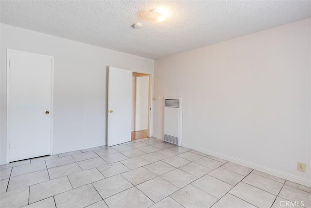 tiled spare room with a textured ceiling