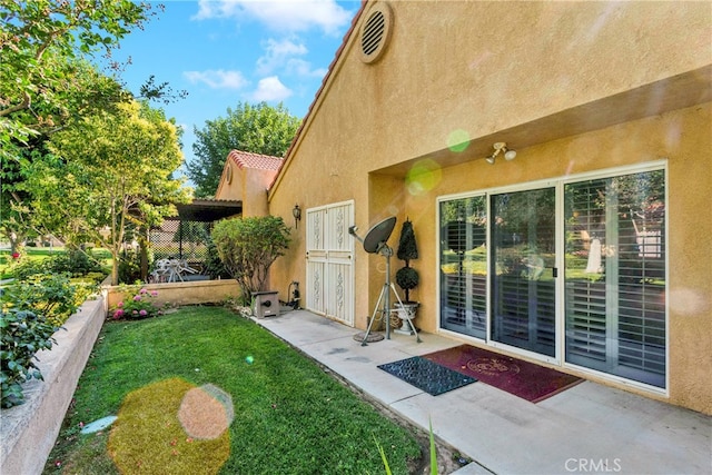 exterior space featuring a lawn and a patio area