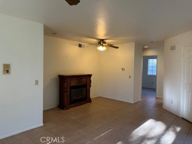 unfurnished living room with ceiling fan, light tile patterned flooring, and a textured ceiling