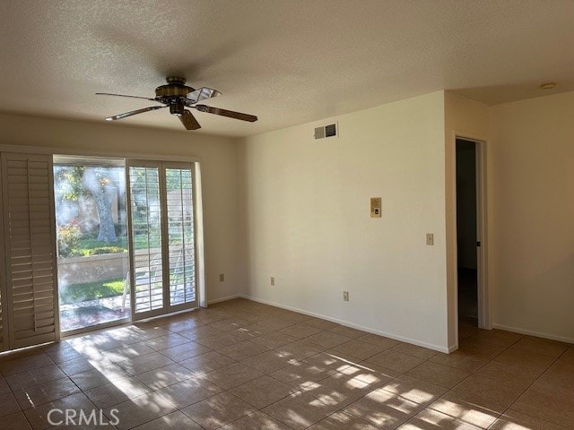 spare room featuring tile patterned floors, a textured ceiling, and ceiling fan