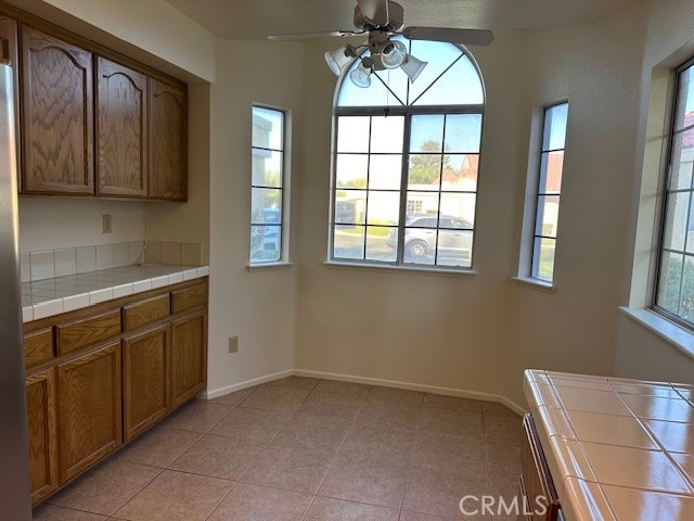 kitchen featuring ceiling fan, a wealth of natural light, and tile counters