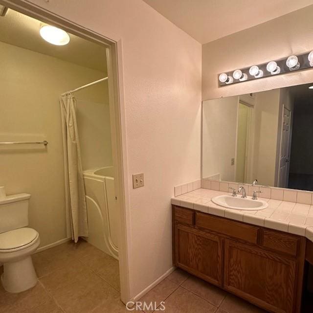 11611 Park Ln, Apple Valley, CA 92308 - bathroom featuring toilet, washer and clothes dryer, tile patterned flooring, and baseboards