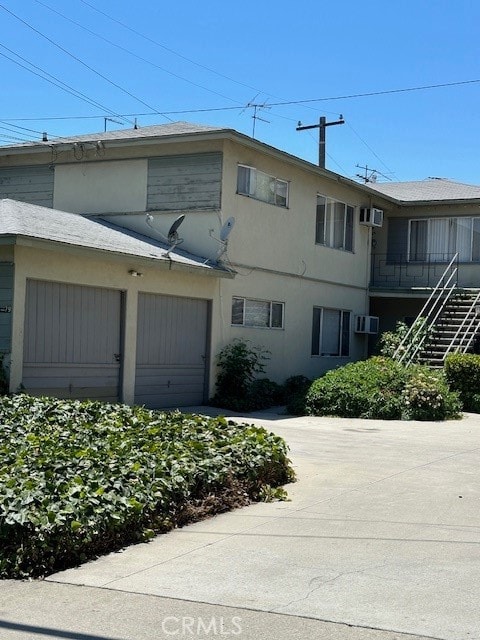 view of building exterior featuring a wall mounted AC and a garage