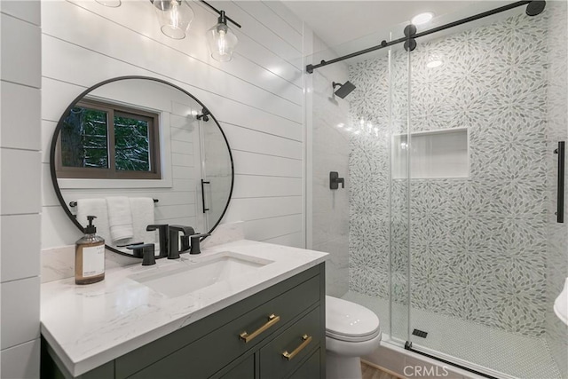 bathroom featuring vanity, wood walls, toilet, and walk in shower