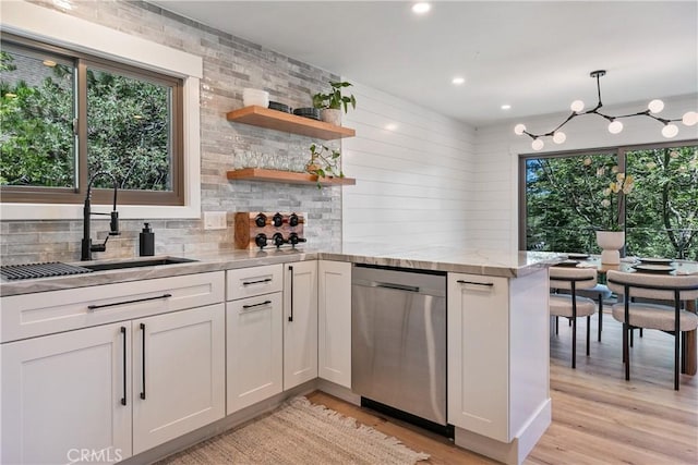 kitchen with dishwasher, sink, pendant lighting, light hardwood / wood-style floors, and white cabinets