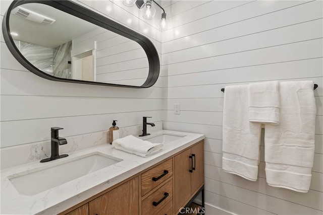 bathroom with vanity and wood walls