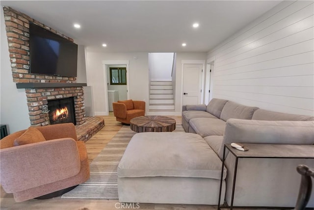 living room featuring light wood-type flooring and a brick fireplace