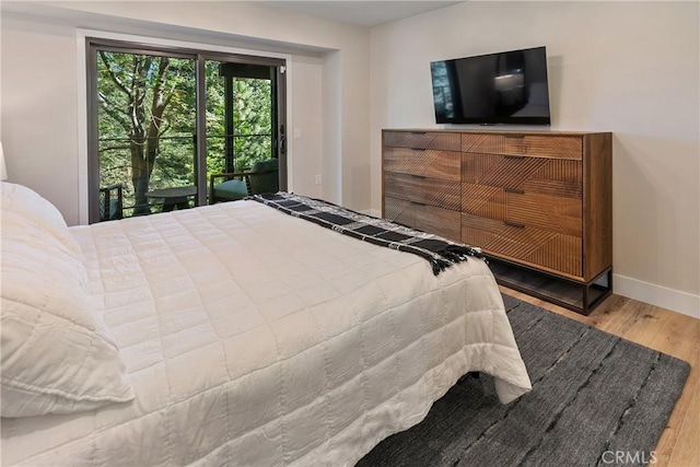 bedroom with access to outside and hardwood / wood-style flooring