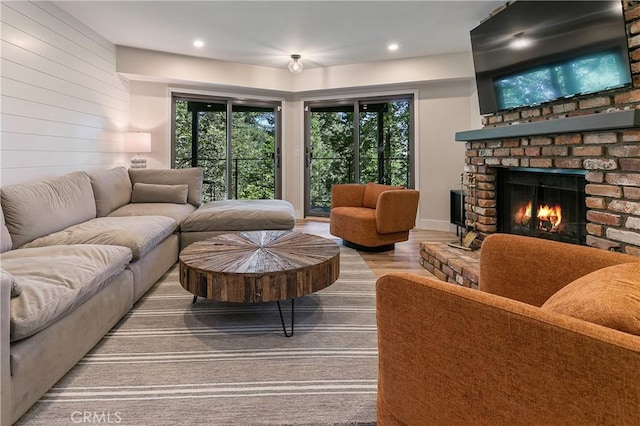 living room featuring wood-type flooring and a brick fireplace