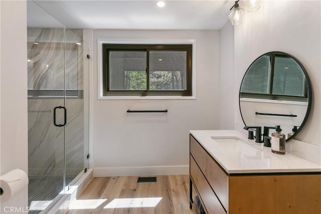 bathroom featuring hardwood / wood-style flooring, vanity, and walk in shower